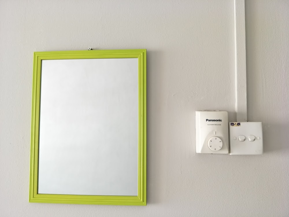 Wall mirror and light switches in room — House 175, bilik sewa pekerja di Taman Senai Baru, Senai